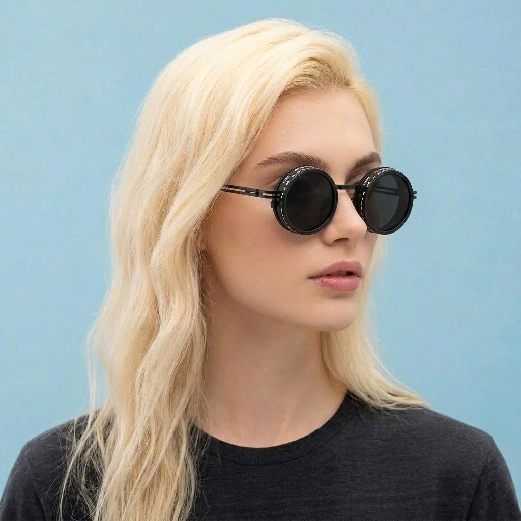 Woman wearing round sunglasses against a light blue background